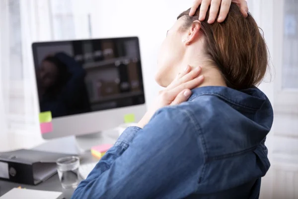 Rückansicht einer müden Bürofrau, die sich den Nacken massiert — Stockfoto