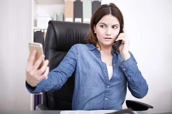 Mujer hablando por teléfono y revisando su móvil —  Fotos de Stock