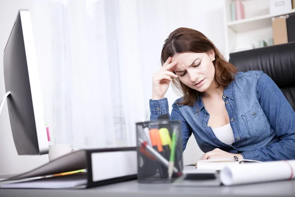Беспокойная деловая женщина за своим столом в офисе — стоковое фото