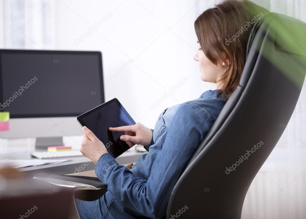 Office Woman at her Table Browsing at her Tablet