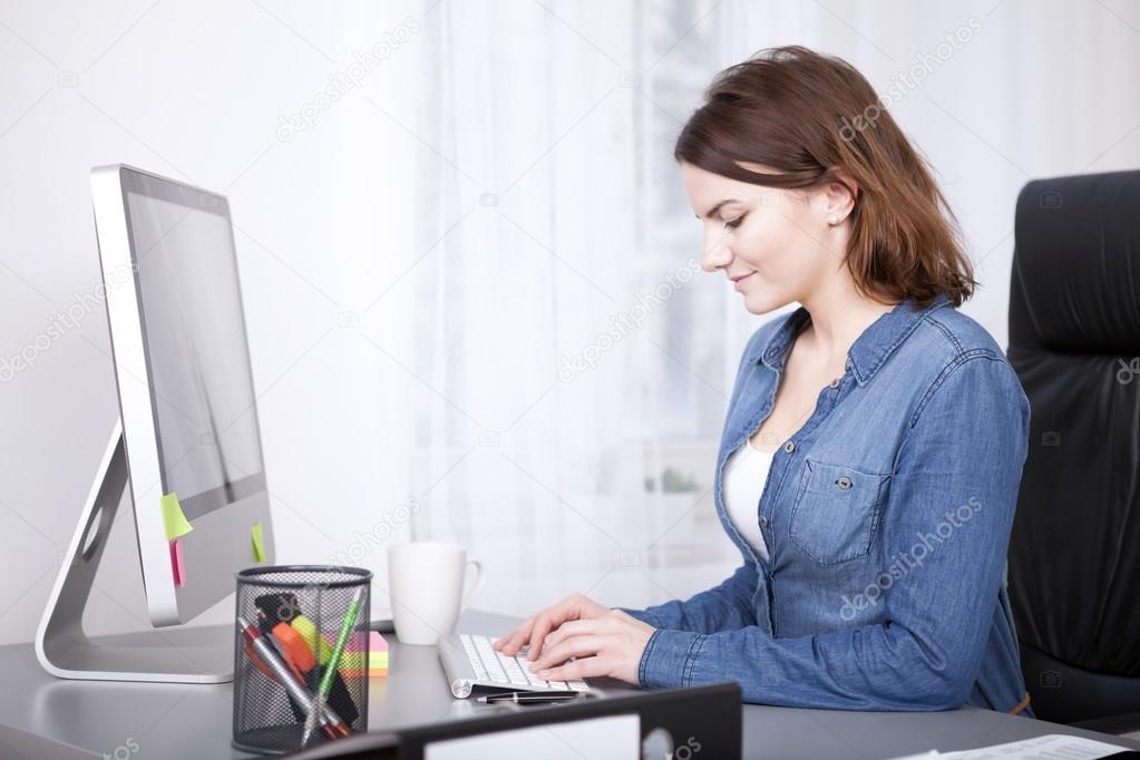 Smiling businesswoman inputting data