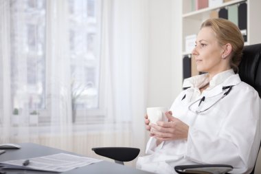 Sandalyede oturan içkiyle dalgın tıp doktor