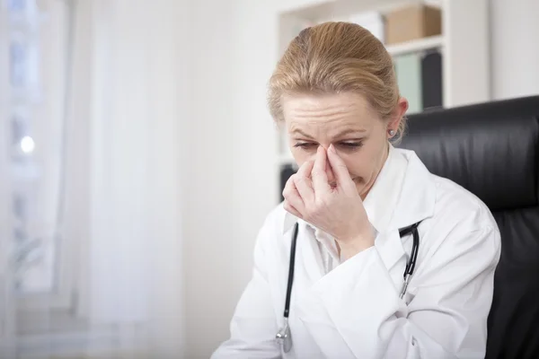 Stressed Female Doctor Holding her Nose Bridge — Stock Photo, Image