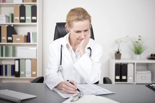 Médecin féminin réfléchi étudiant les résultats médicaux — Photo