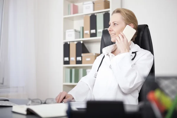 Zufriedene Ärztin telefoniert mit dem Handy — Stockfoto