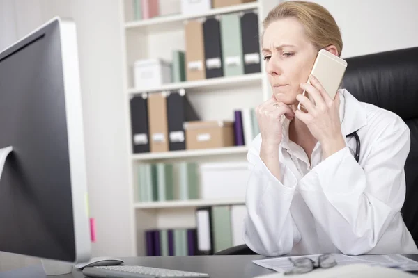 Kobieta lekarz słucha z kimś przez telefon — Zdjęcie stockowe