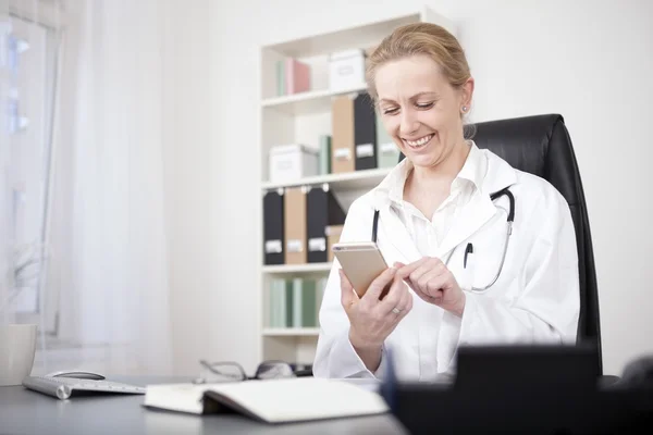 Lycklig kvinna läkare chattar på sin mobiltelefon — Stockfoto