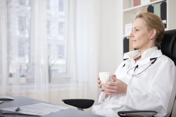 Pensive Medical Doctor with Drink Sitting on Chair — Stock Photo, Image