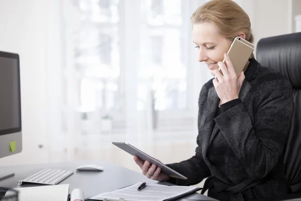 Heureuse femme d'affaires avec tablette parlant au téléphone — Photo
