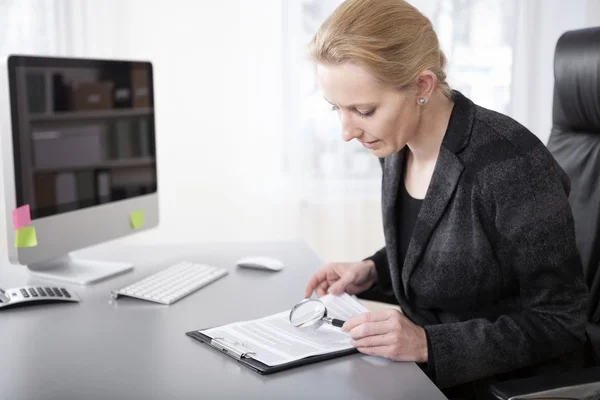 Föreståndarinnan behandlingen detaljer med förstoringsglas — Stockfoto