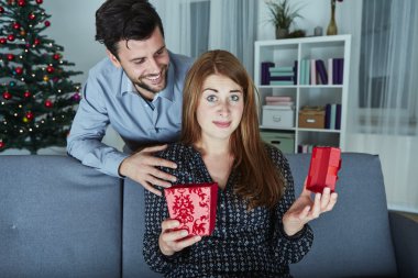 girlfriend looks sceptical to her christmas gift clipart