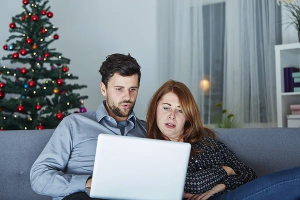 Lyckliga par ser på laptop dator till jul — Stockfoto