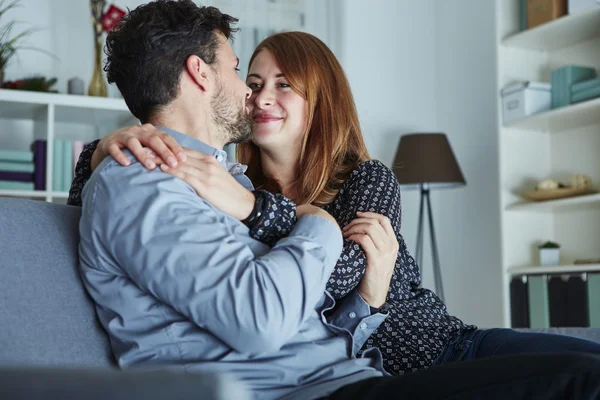 Joven feliz pareja abrazo en sofá —  Fotos de Stock