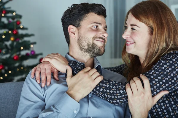 Unga lyckliga paret kram på soffa — Stockfoto