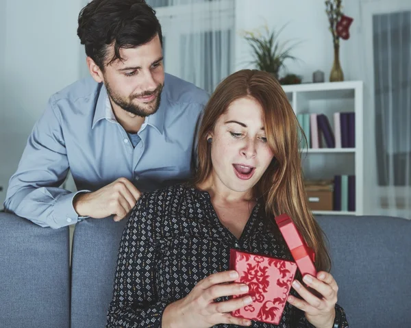 Junges Paar freut sich über Geschenk zu Weihnachten — Stockfoto