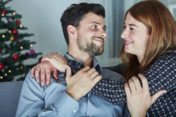 Jovem casal feliz abraço no sofá Fotos De Bancos De Imagens