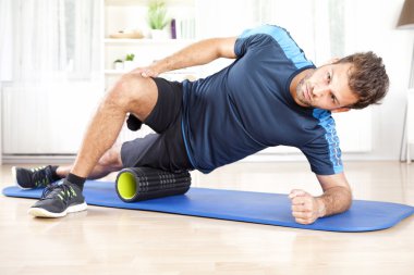 Köpük Roller kullanarak yan Planking atletik erkek