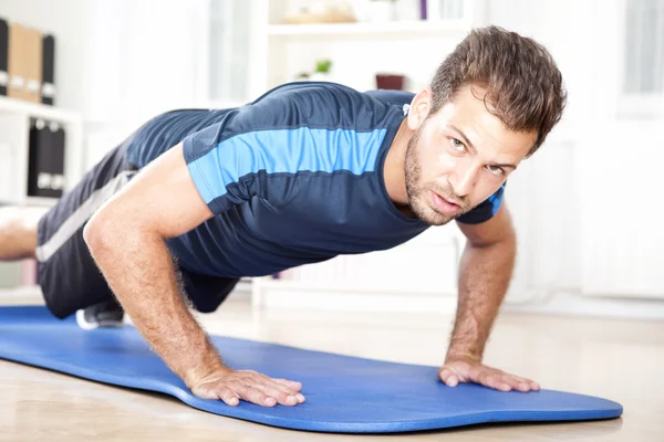 Muscular Man Looking at you while Doing Push ups — стоковое фото