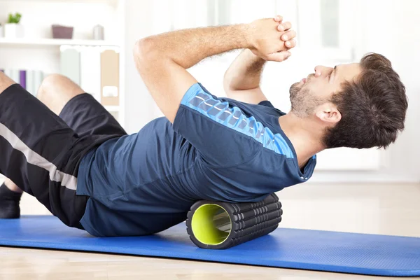 Man Lying on a Foam Roller While Doing an Exercise — Stock Photo, Image