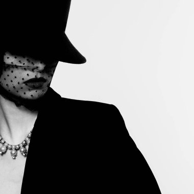 Retro görünümlü zarif bir kadının yüksek moda portresi. Siyah beyaz görüntü, siyah şapka, ceket, kolye.