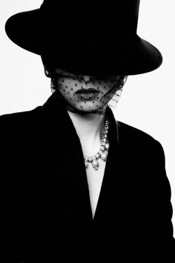 Retro görünümlü zarif bir kadının yüksek moda portresi. Siyah beyaz görüntü, siyah şapka, ceket, kolye.