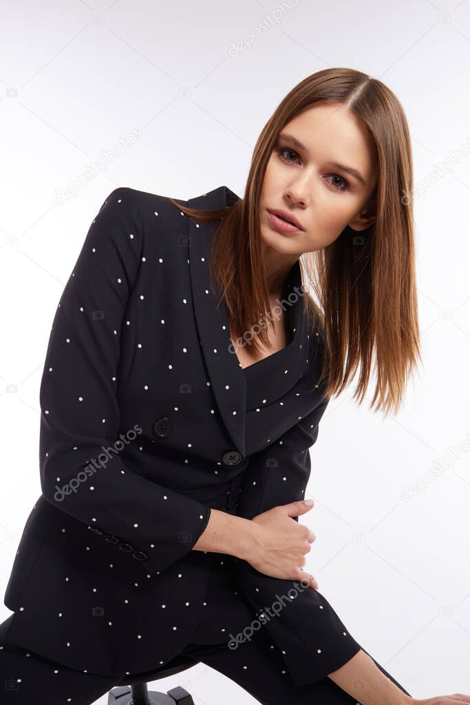 High fashion portrait of young elegant woman in black suit. Studio shot.