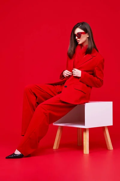 赤いスーツとサングラスのファッションモデル スタジオショット — ストック写真