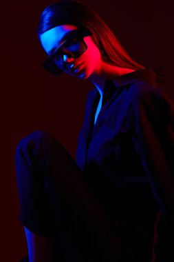 Moda gözlüklü zarif bir kadının moda portresi. Neon lambası, stüdyo çekimi.