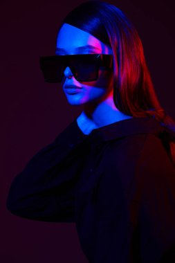 Moda gözlüklü zarif bir kadının moda portresi. Neon lambası, stüdyo çekimi.