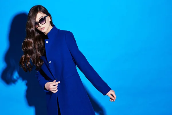 若いエレガントな女性の高ファッションの肖像画 青いコート バッグ 青の背景 — ストック写真