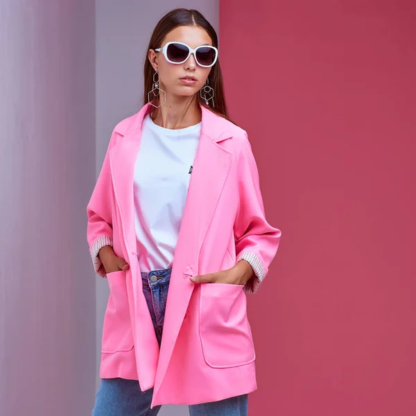 若いエレガントな女性のファッションの肖像画 ピンクのジャケット 青いジーンズ サングラス スタジオショット — ストック写真