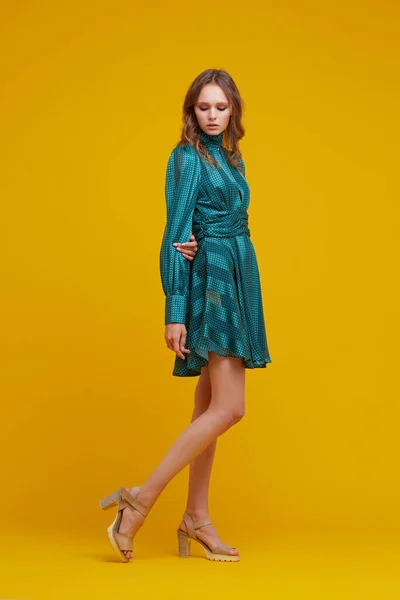 Yeşil Elbiseli Güzel Bir Genç Kadın Sarı Arka Plan Moda — Stok fotoğraf