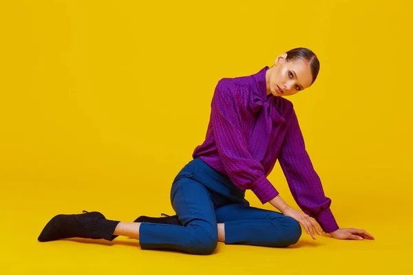 年轻优雅女子的高级时尚肖像 苏迪欧开枪了紫罗兰衬衫 蓝色裤子 脚踝靴 黄色背景 — 图库照片