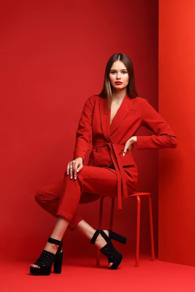 Fashion Wanita Muda Dalam Setelan Merah Latar Merah — Stok Foto