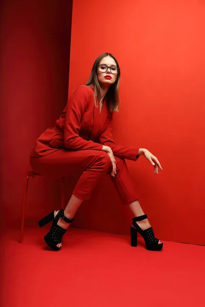 Fashion Wanita Muda Dalam Setelan Merah Latar Merah — Stok Foto