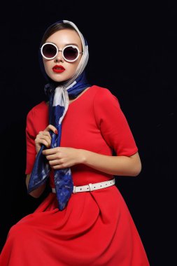 Geçmişe dönük genç bir kadın. Güneş gözlüğü ve ipek eşarp. 60 'ların moda retro kadını. 