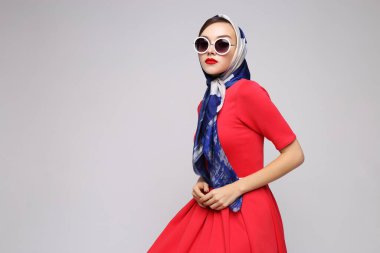 Geçmişe dönük genç bir kadın. Güneş gözlüğü ve ipek eşarp. 60 'ların moda retro kadını. 