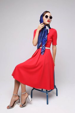 Geçmişe dönük genç bir kadın. Güneş gözlüğü ve ipek eşarp. 60 'ların moda retro kadını. 