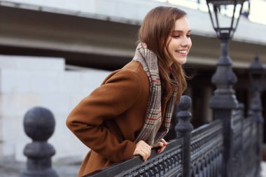 Modayı takip eden genç bir bayan. Paltosu, atkısı ve el çantası vardı. 