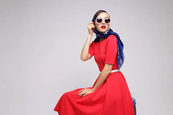 Young woman in retro style. Sunglasses and silk scarf. Sixties style fashion retro woman.