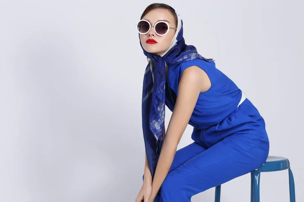 年轻女子的复古风格 太阳镜和丝巾蓝色工作服六十年代风格时尚复古女人 — 图库照片