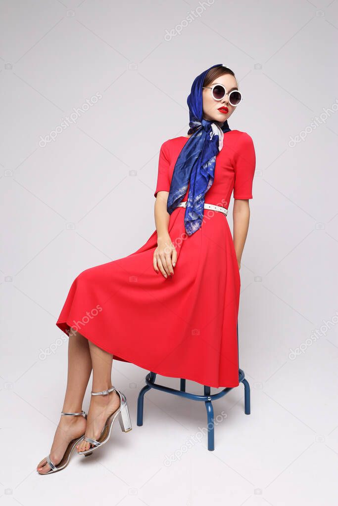 Young woman in retro style. Sunglasses and silk scarf. Sixties style fashion retro woman. 