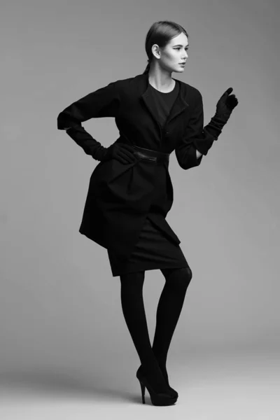 Високий модний портрет елегантної жінки в чорному пальто. Студійне взуття — стокове фото