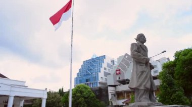 Endonezya bayrağı ve Yogyakarta parlamento binası olan General Sudirman 'ın Endonezya Kahramanı askeri heykeli. 26 Mart 2021 'de, Endonezya' nın Yogyakarta şehrinde çekildi.