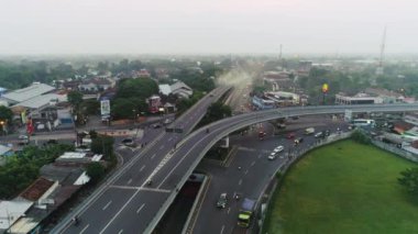 Yanlamasına uçan İHA 'nın hava görüntüleri. Sisli ufuk arkaplanlı üstgeçit yolu kavşağı görüntüsü. 4 Haziran 2021 'de Endonezya' nın Yogyakarta şehrinde çekildi.