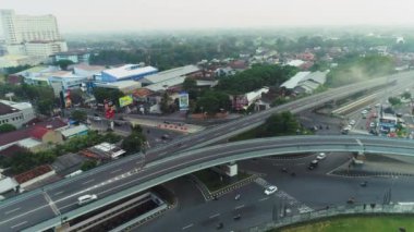 Şehrin sisli arka planına sahip çok şeritli üstgeçit yolu ve köprüyü gösteren hava görüntüleri. 4 Haziran 2021 'de Endonezya' nın Yogyakarta şehrinde çekildi.