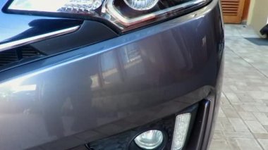 Gri modern araba, ön tarafında LED far olan parlak bir vücut görünümüne sahip.