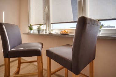 Loggia 'da açık renkli sandalyeli yemek masası.