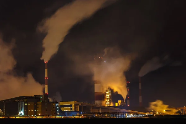 night industrial landscape environmental pollution waste of thermal power plant. Big pipes of chemical industry enterprise plant