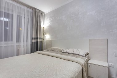 MINSK, BELARUS - Eylül 2020: Stüdyo dairelerdeki modern lüks yatak odasının içi açık renkli